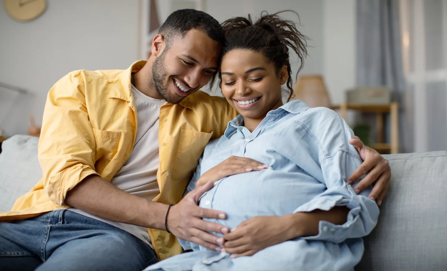 a photo of a pregnant woman and her partner holding her stomach